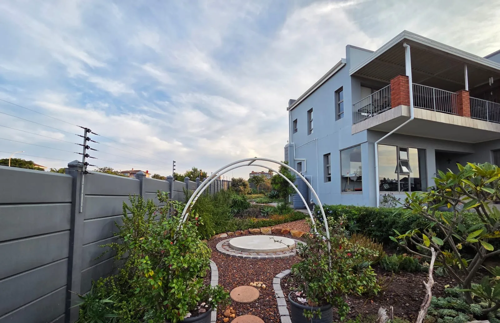 A paved circle and garden arch among the planting